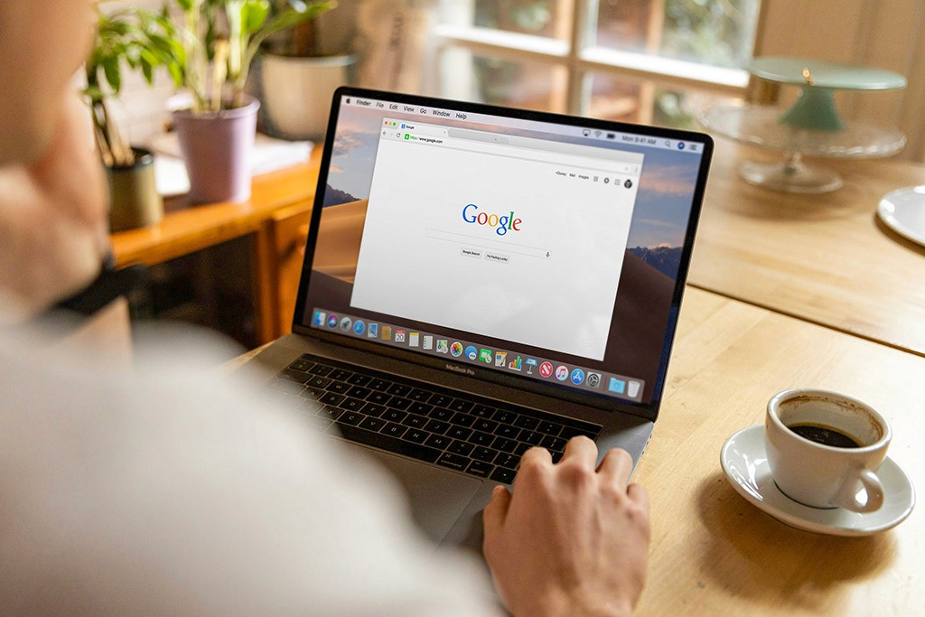 Une personne effectue une recherche sur Google avec un ordinateur portable.