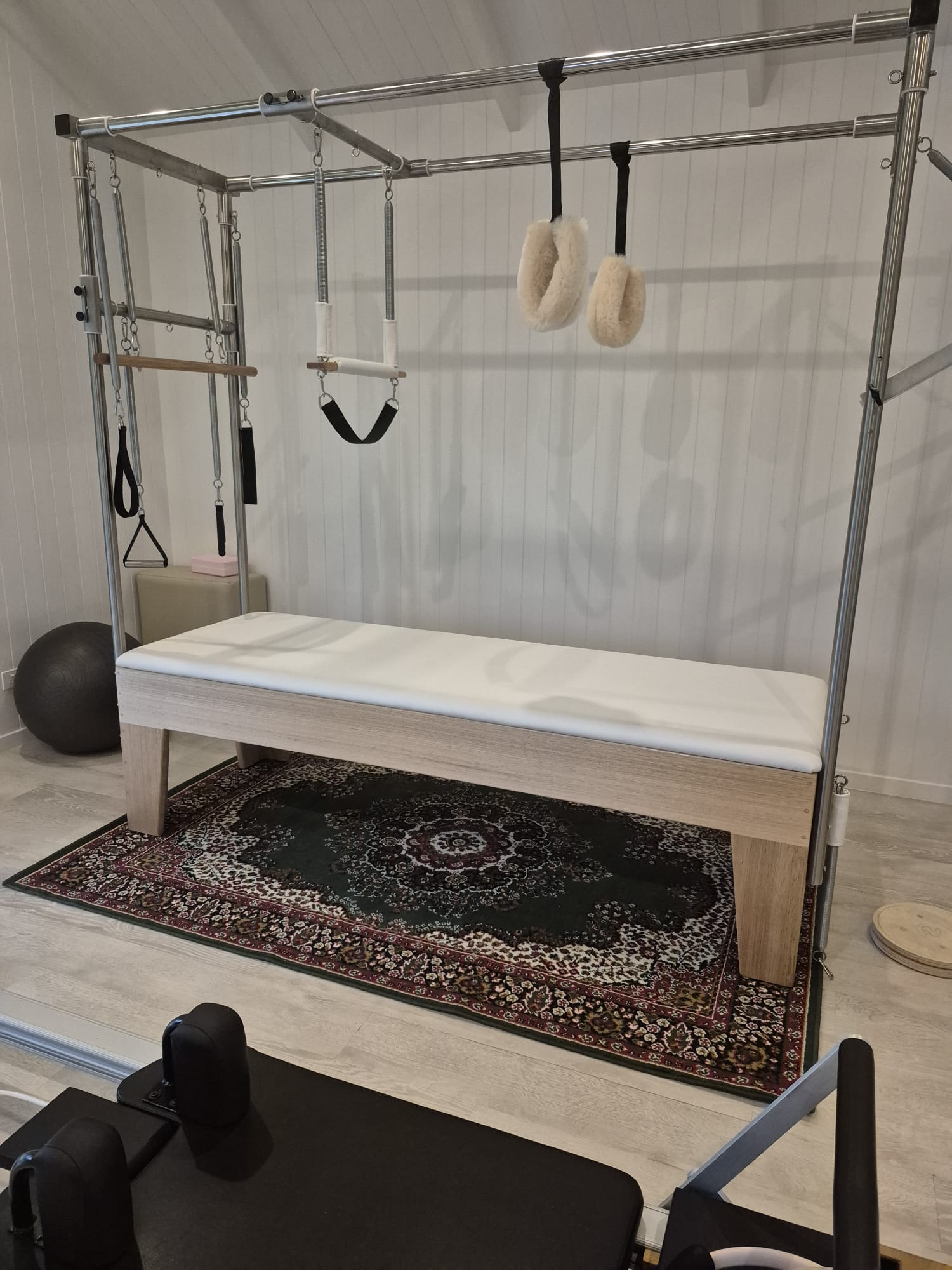 Reformer Pilates equipment in a serene, white homestead studio surrounded by natural light.