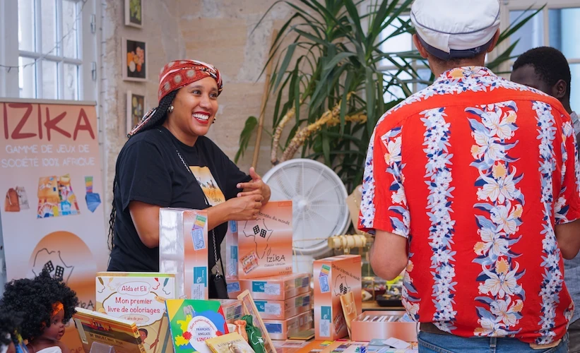 Stand pop-up store Douhomé — créatrice présentant ses produits à un visiteur