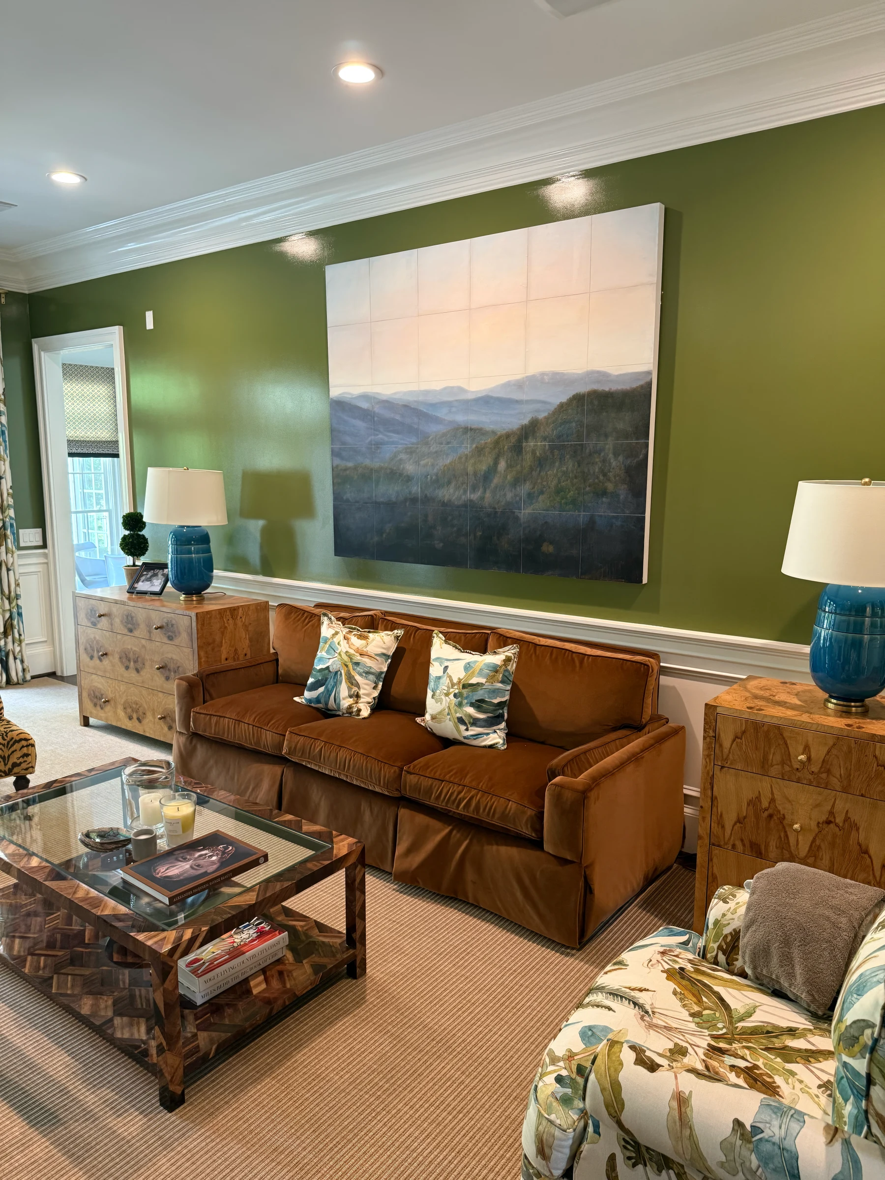 An angled view of the landscape canvas, sofa and surrounding wall trim.