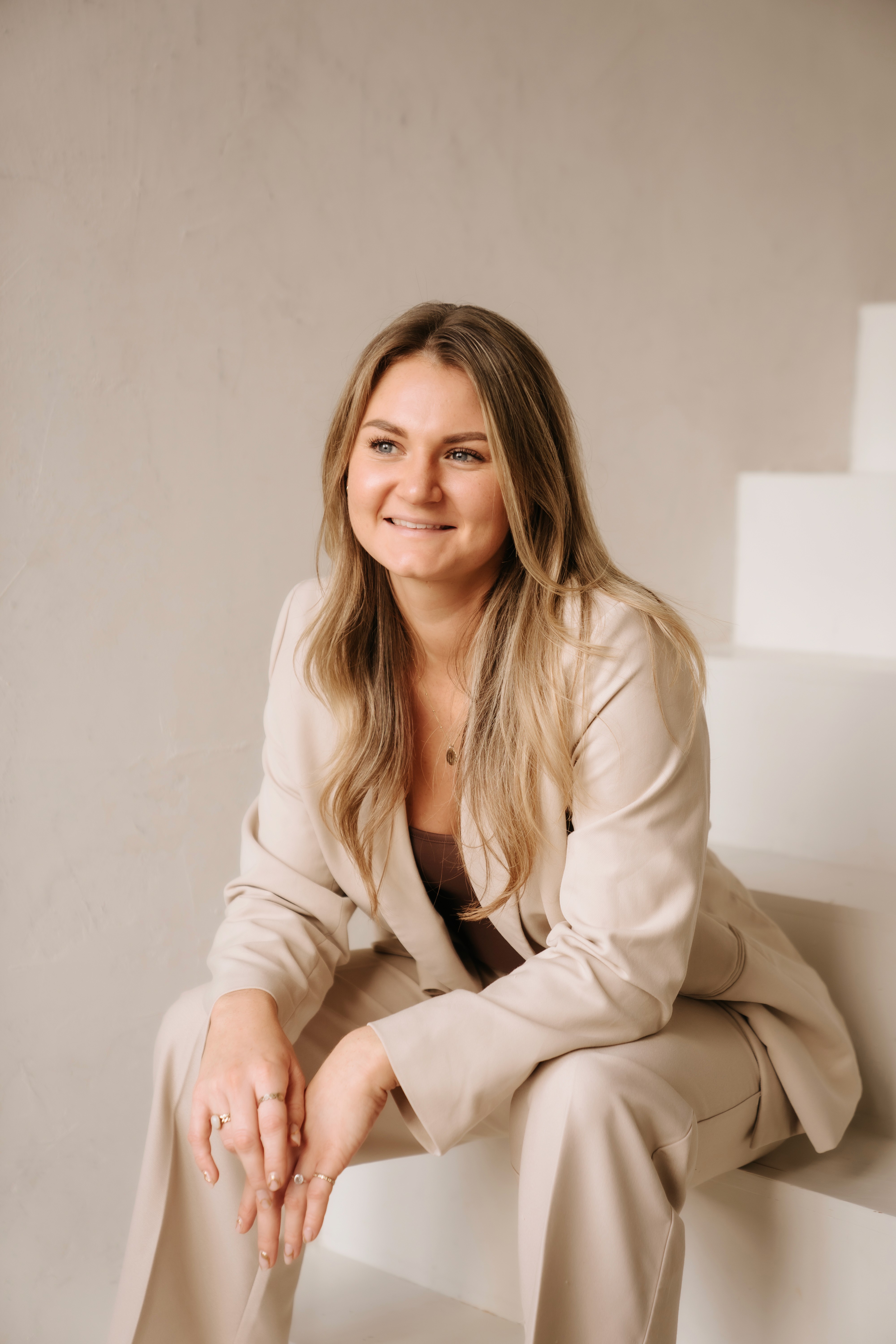 person writing on brown wooden table near white ceramic mug