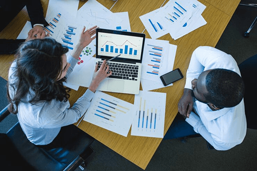 Investment bankers analysing various data from different sources