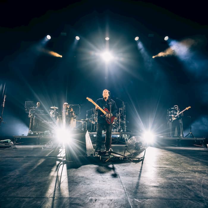 Performer under spotlight on dark stage