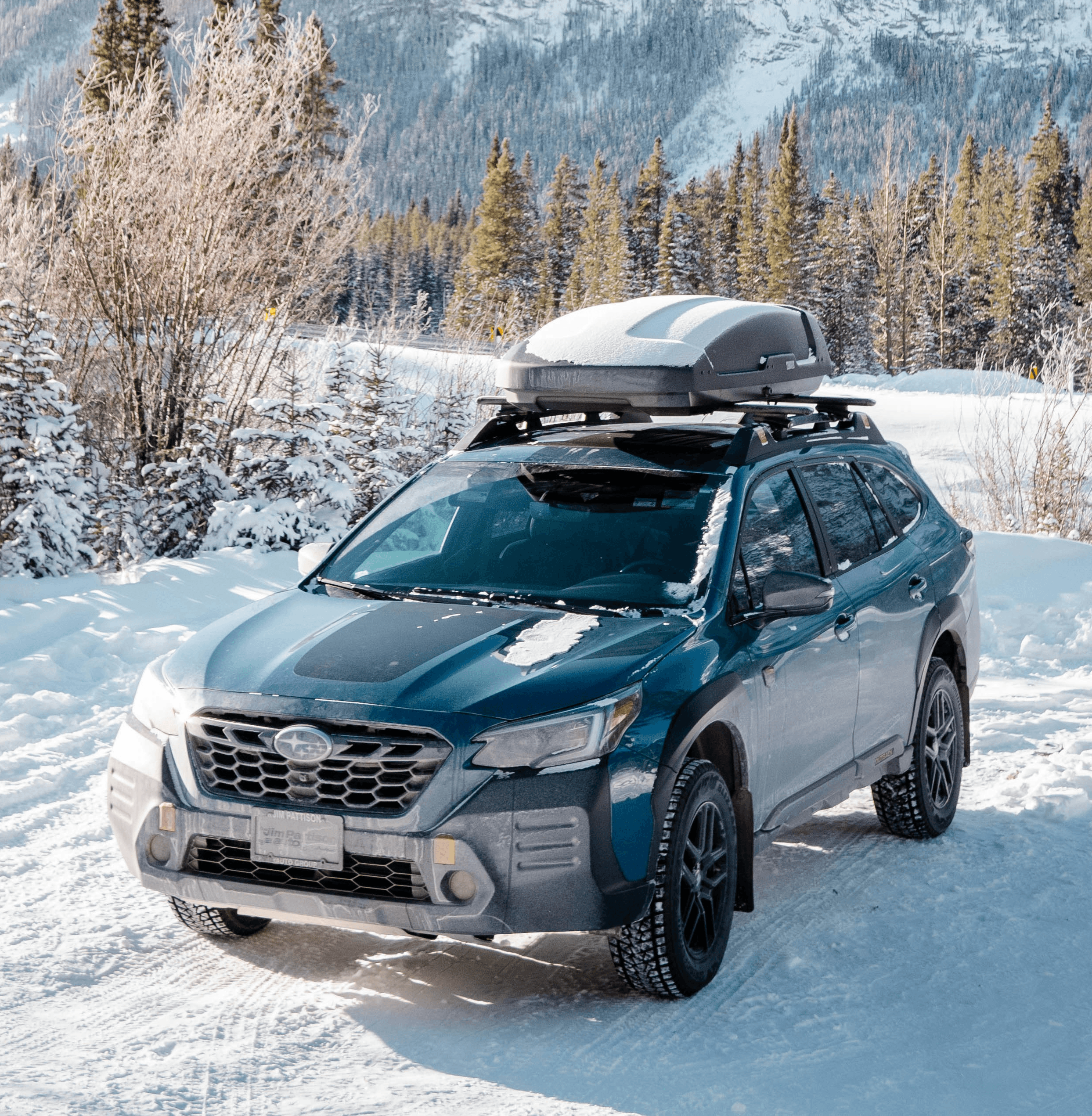 a car parked in the snow in front of a mountain