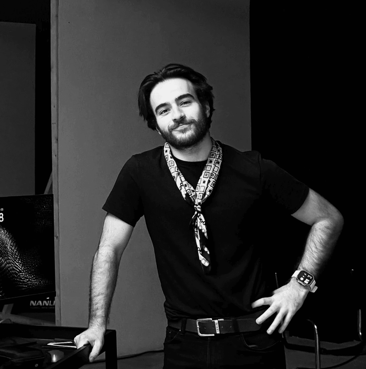 Young man in a tweed jacket and patterned silk scarf.