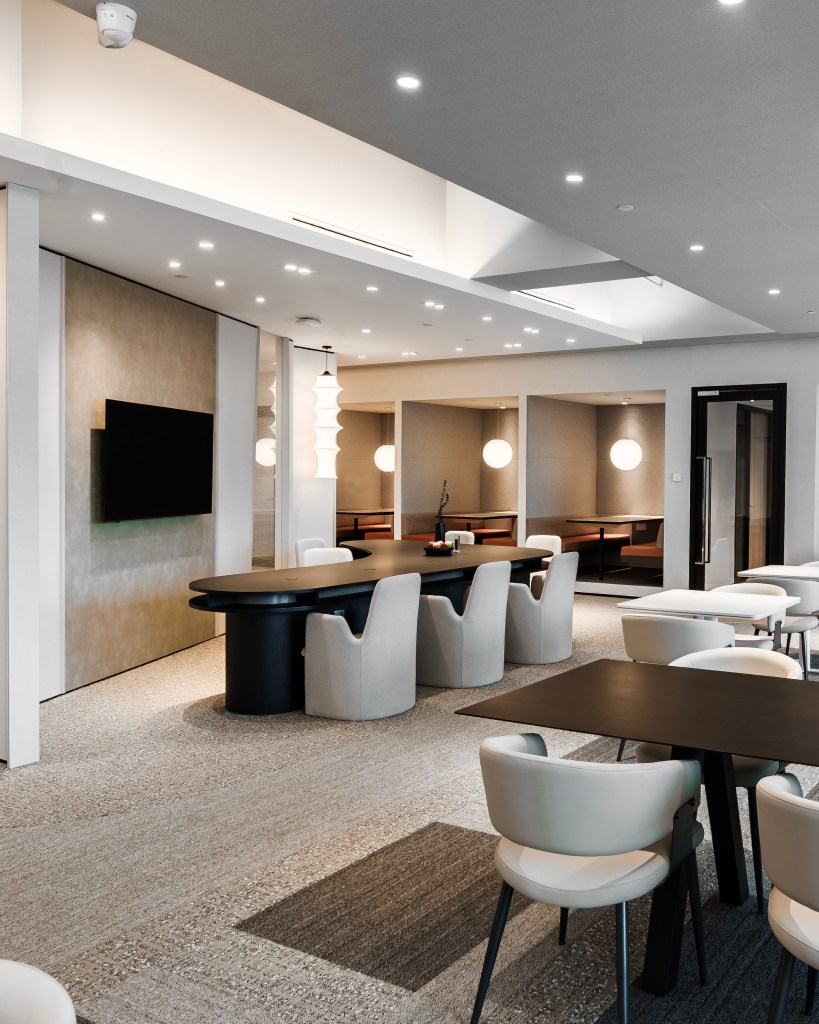 A modern coworking space featuring stylish furniture, sleek lighting, and a spacious layout designed for collaboration and creativity.