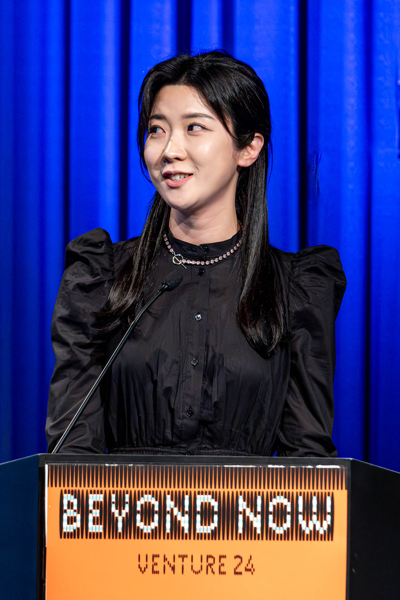 a student at a podium presenting a project in a Theatre