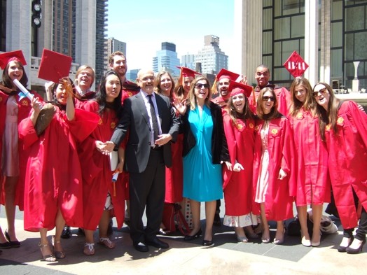 students in red ropes at graduation with two professors