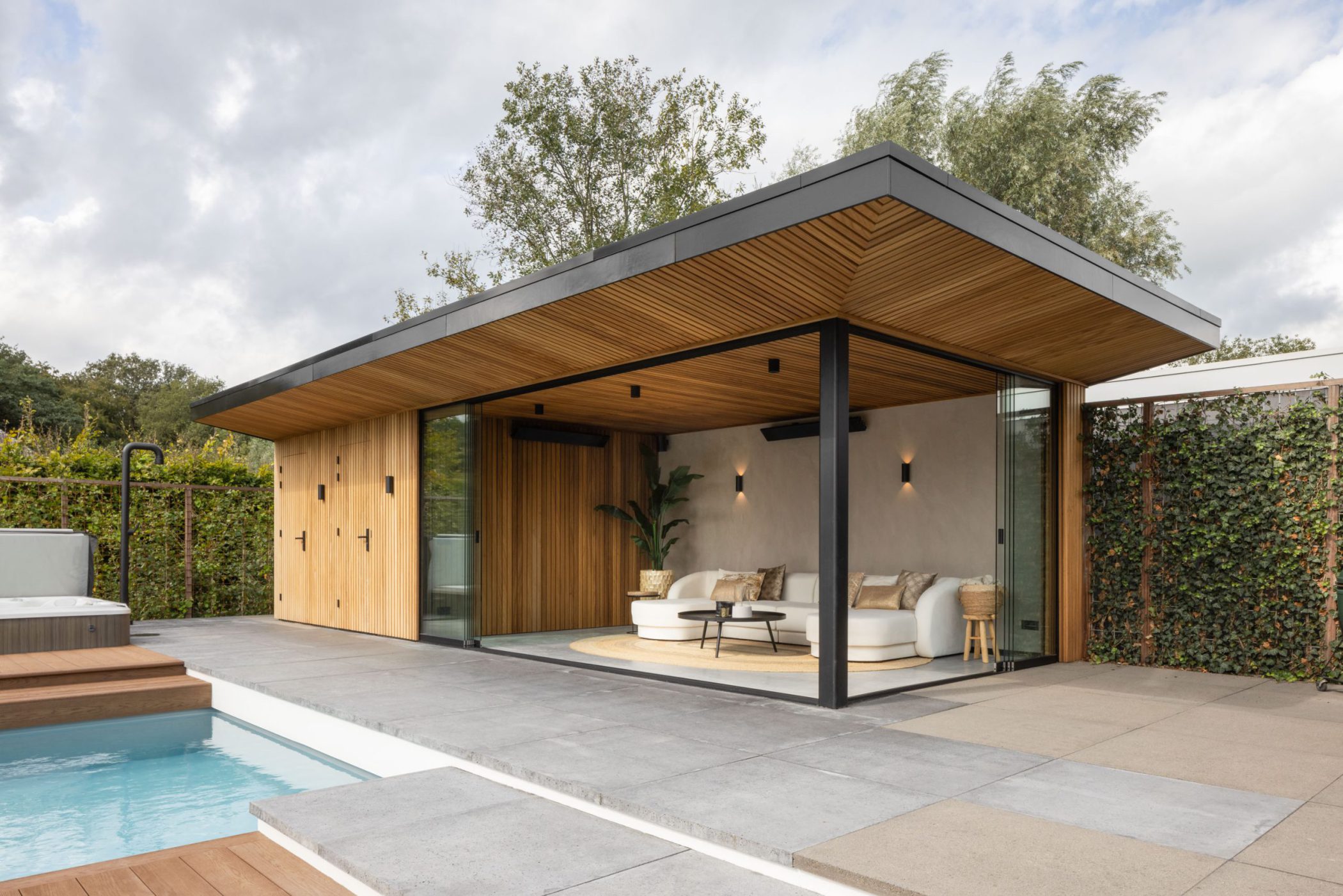 Out-Standing poolhouse with a wooden ceiling next to a swimming pool