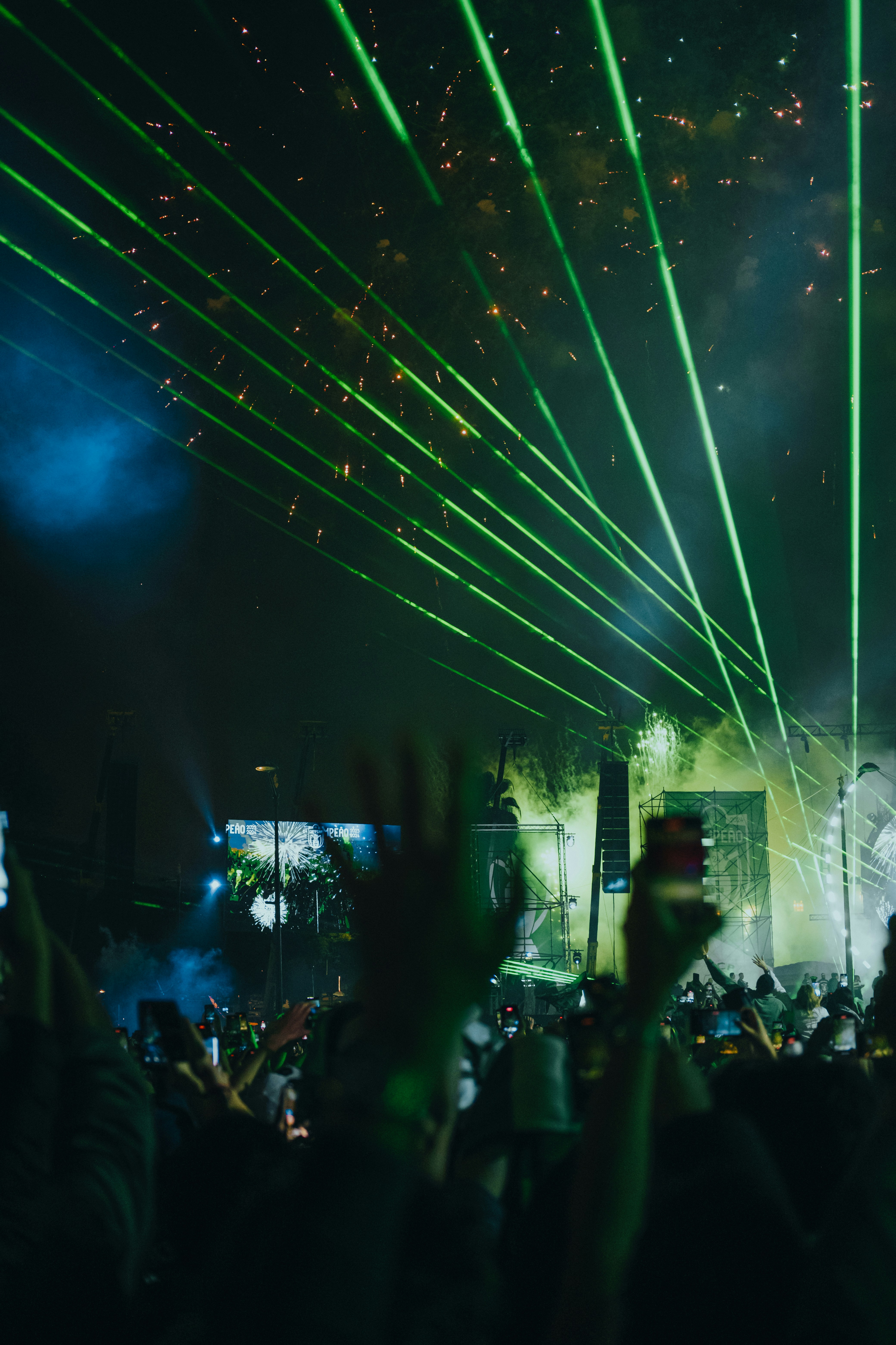 A crowd of people at a concert with their hands in the air