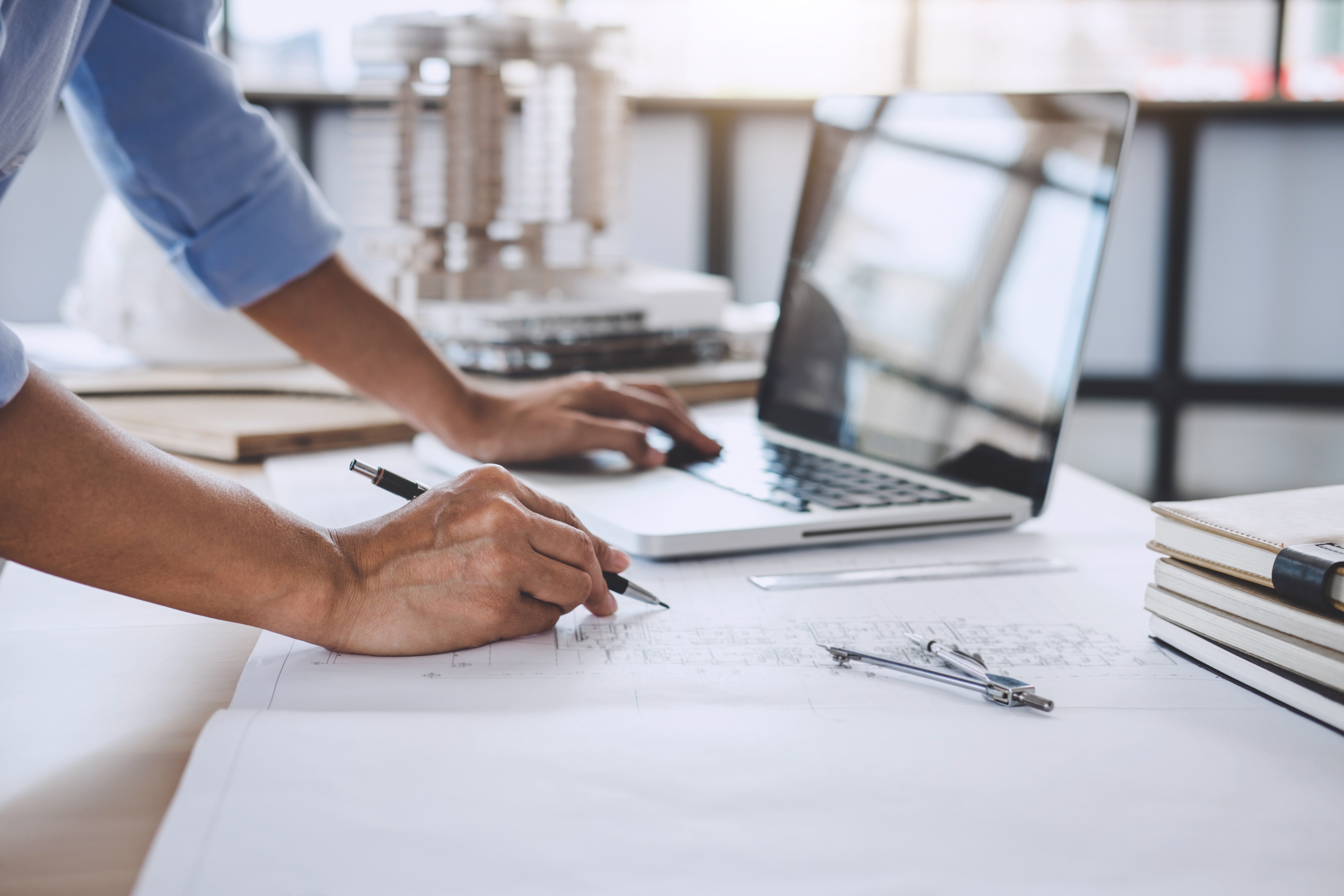 Documents de travail étalés sur un bureau à côté d'un ordinateur portable