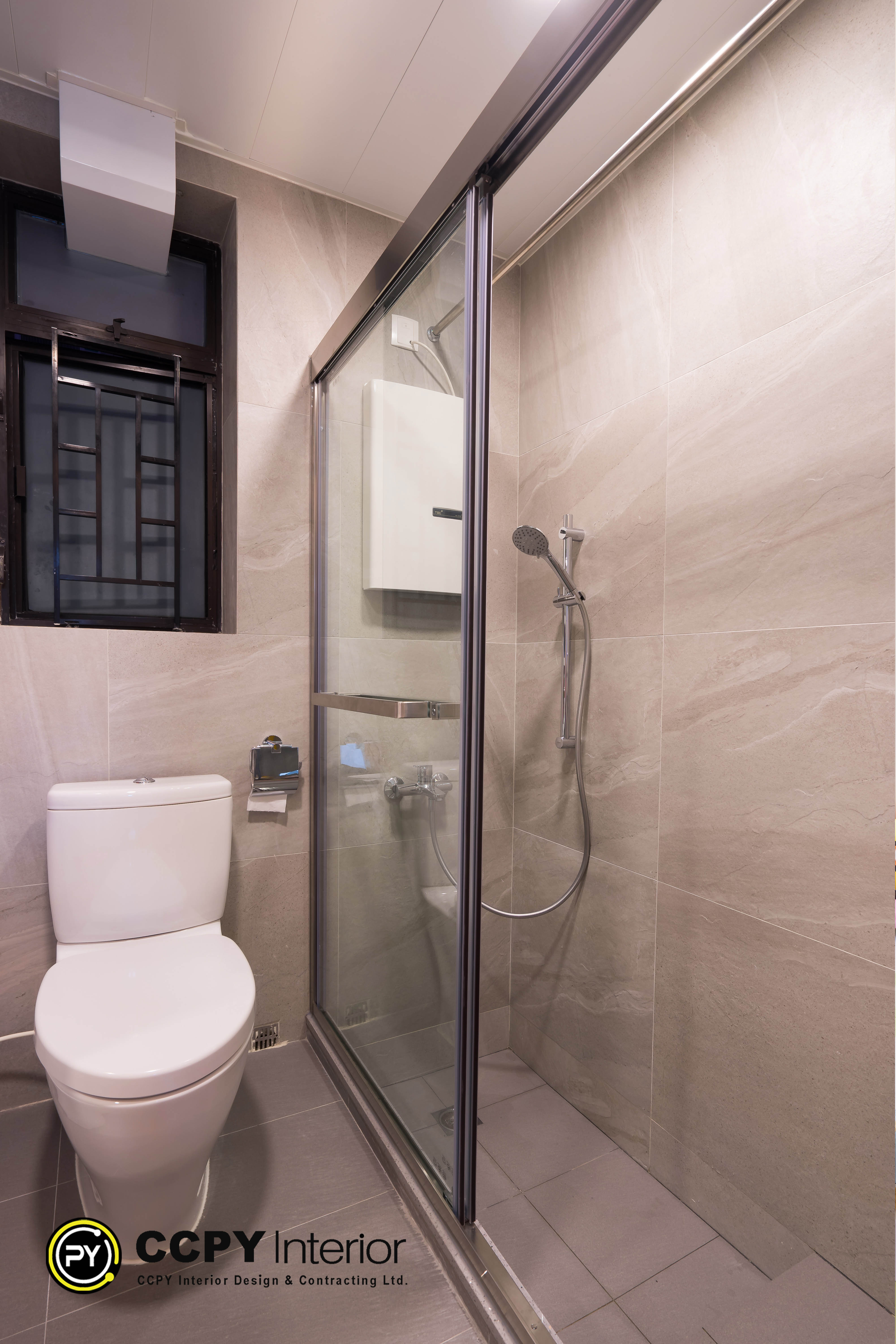 Frameless glass defines the modern bathroom design in Castello, where textured grey porcelain tiles provide a tactile backdrop for chrome hardware.