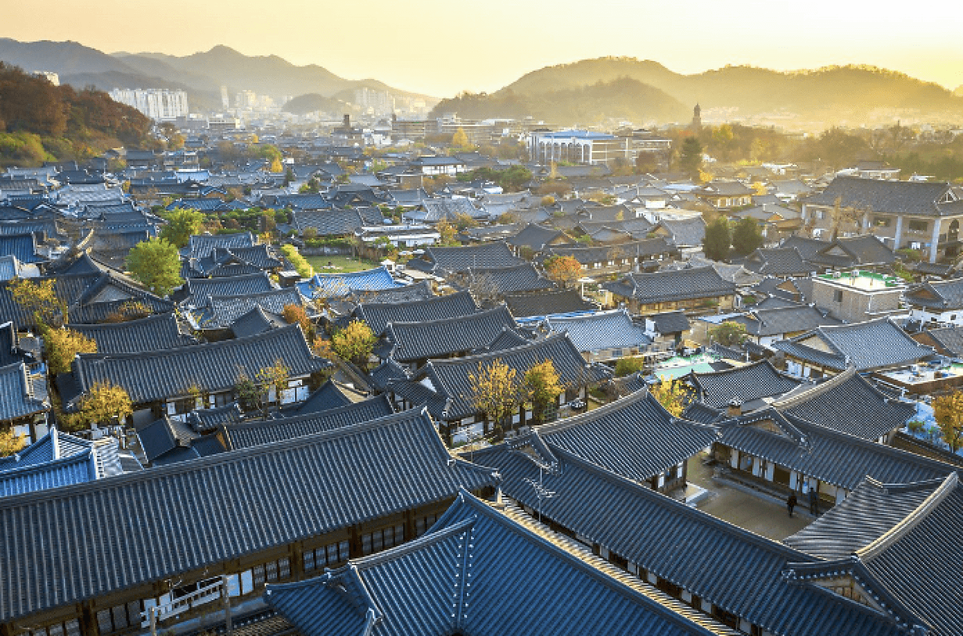 A wooden cube teeters on the edge of a rectangular block against a plain background.
