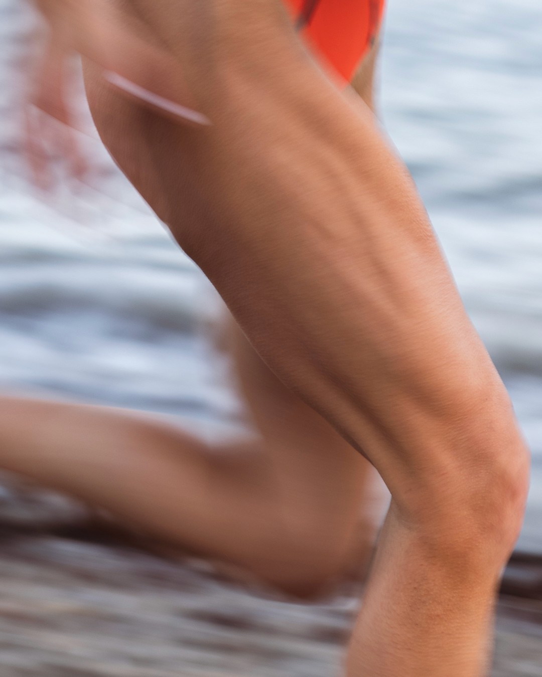 Close-up of athlete wearing Surface Athletics performance swim top, highlighting technical fabric, secure support, and design built for high-performance movement.