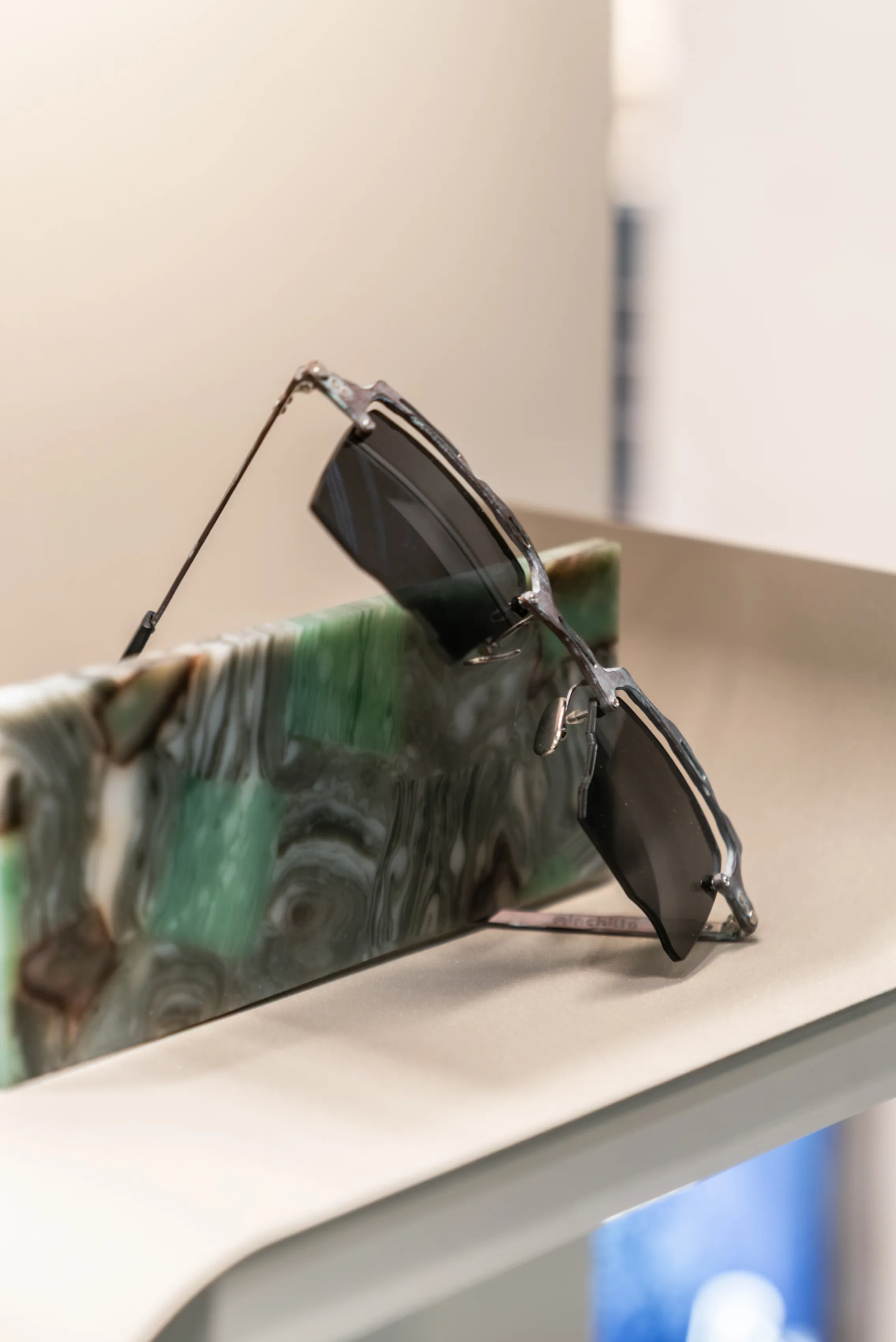 Occhiale IDIA associato ad Alex, fotografato insieme a elementi materici che richiamano la ricerca di texture e colori utilizzata nel progetto. Un esempio di occhiale su misura IDIA di Ottica Dentella ad Ancona, sviluppato attraverso la personalizzazione di forma, materiali, proporzioni e dettagli per creare una montatura coerente con il volto e l’identità personale.