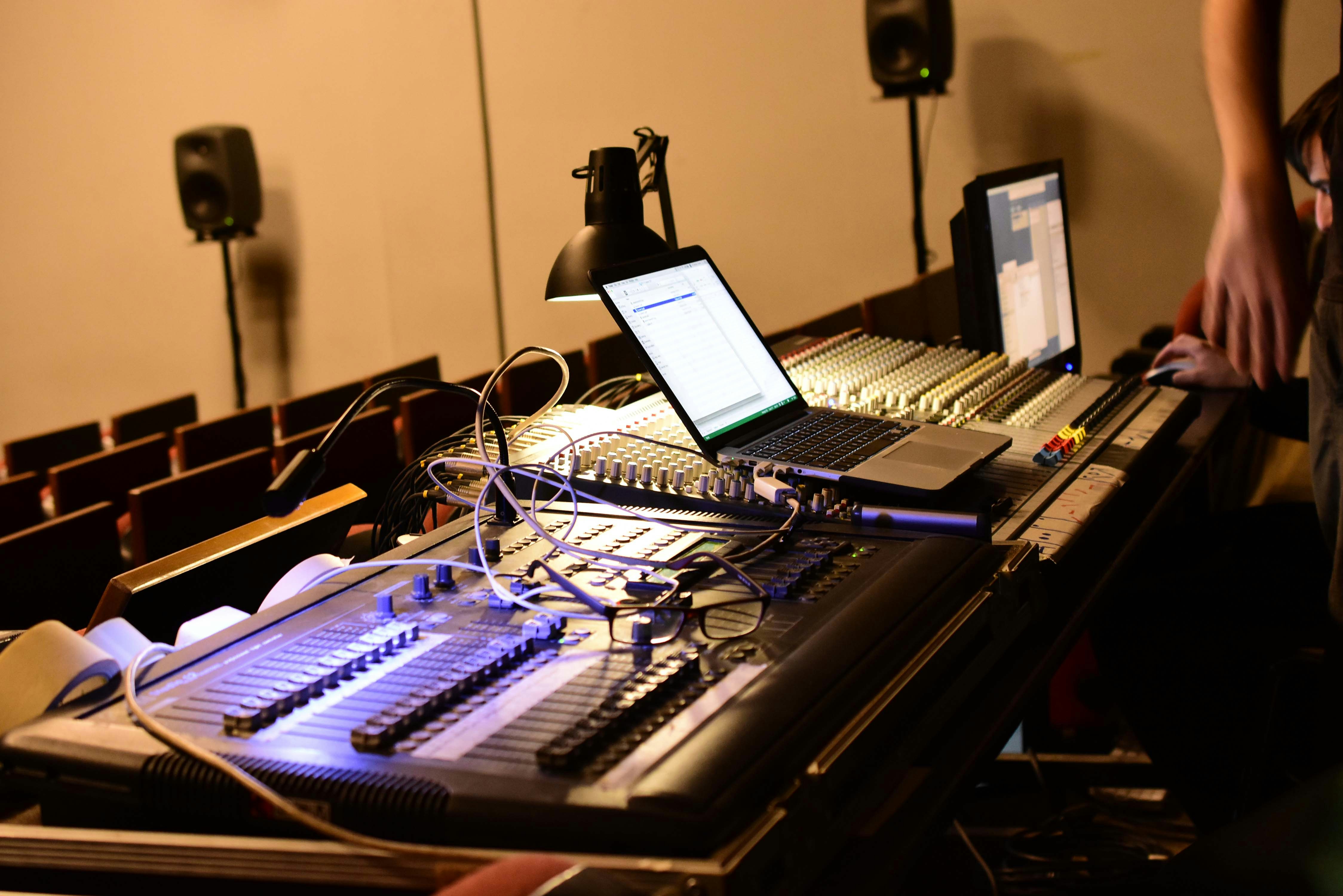 Audio mixing board with laptops and speakers.