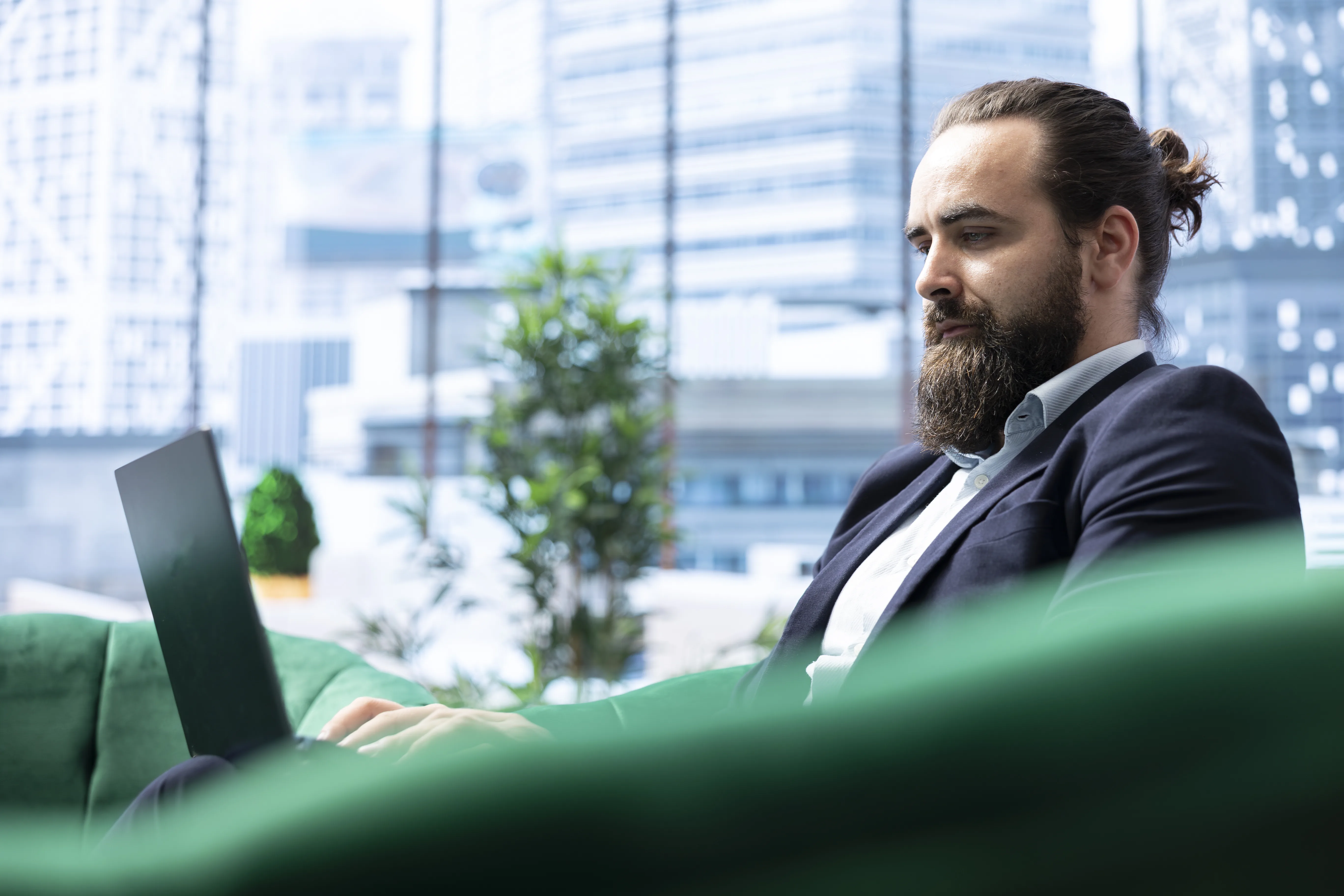 Business professional working on a laptop in an enterprise office environment representing contextual AI governance and enterprise risk exposure.