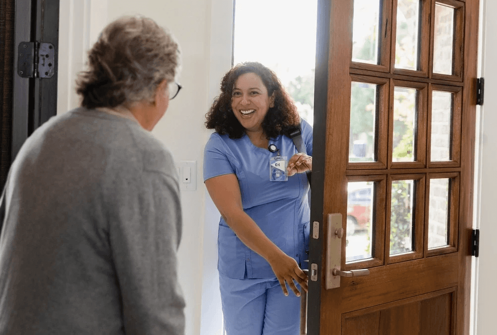 Senior man welcoming a home health aide into his home for care