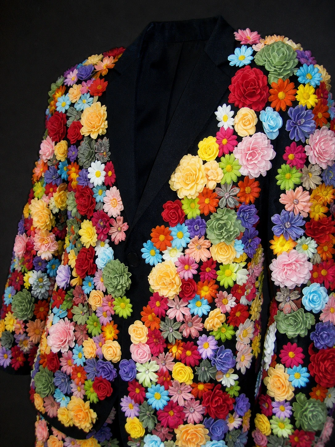 Early-2000s direct-flash detail of Le Fleuravelle flowers and black lapels with no person or room visible.