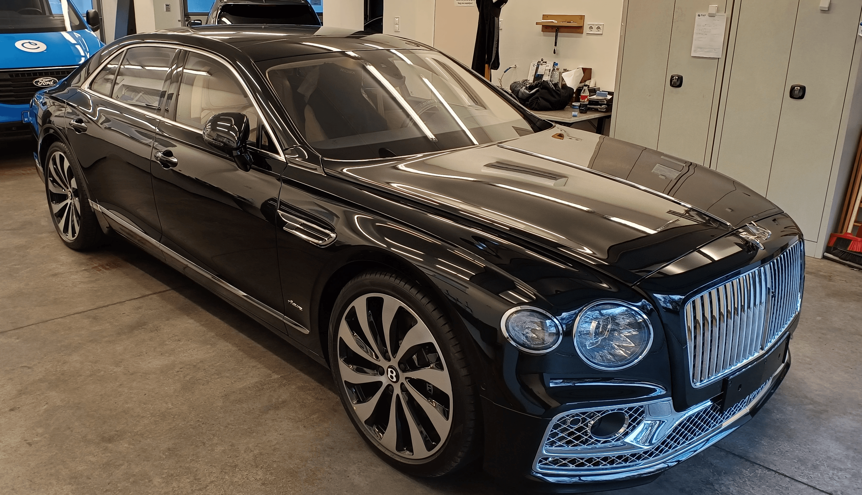 Mélyfekete Bentley Flying Spur luxusautó prémium átlátszó karosszériavédő fóliázás (PPF) után a Nortek műhelyében. Tökéletesen láthatatlan, magasfényű védelem a karcok ellen.