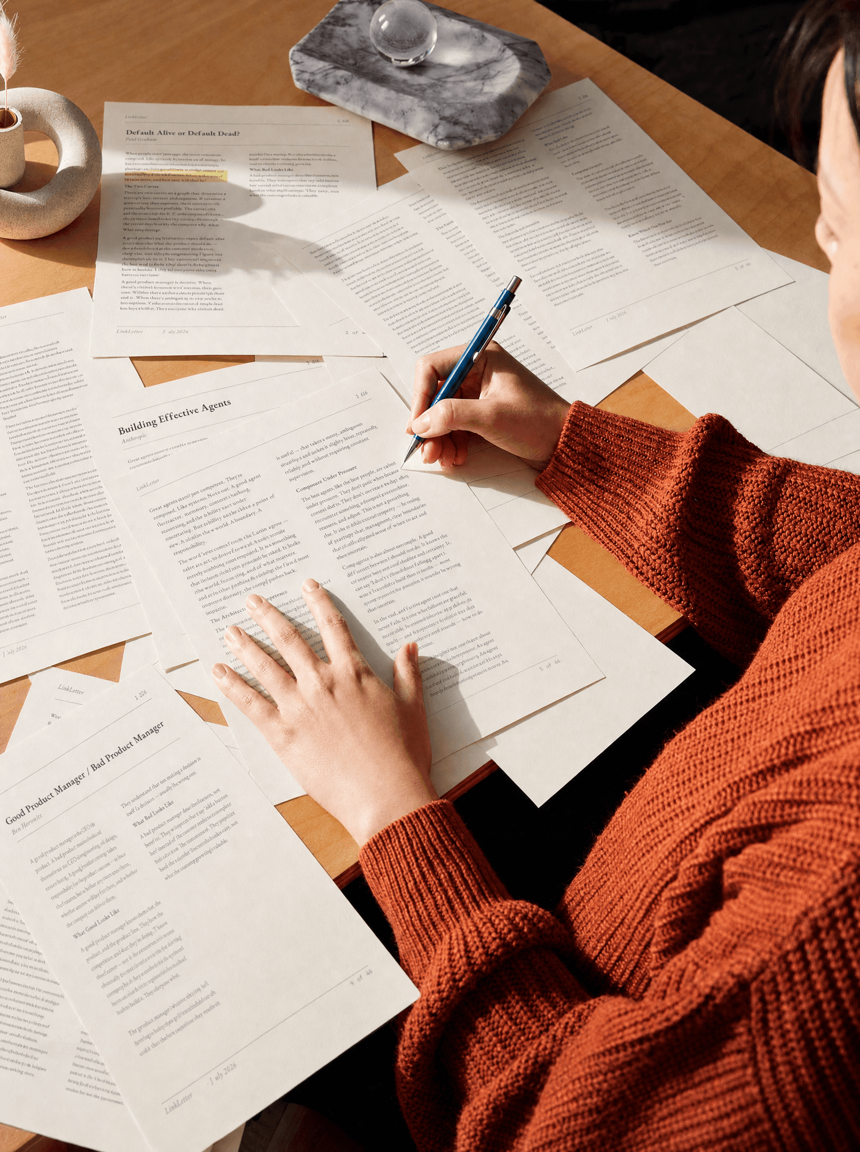 Person reading and annotating a LinkLetter issue