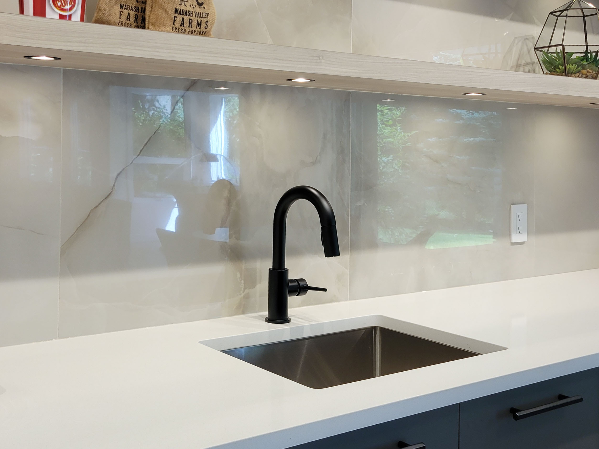 Image of Modern kitchen sink area with black faucet and white countertop by KHD Homes design-build construction.