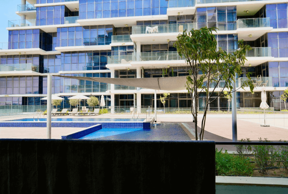 A picturesque lake with a house in the distance, complemented by a golf terrace area.