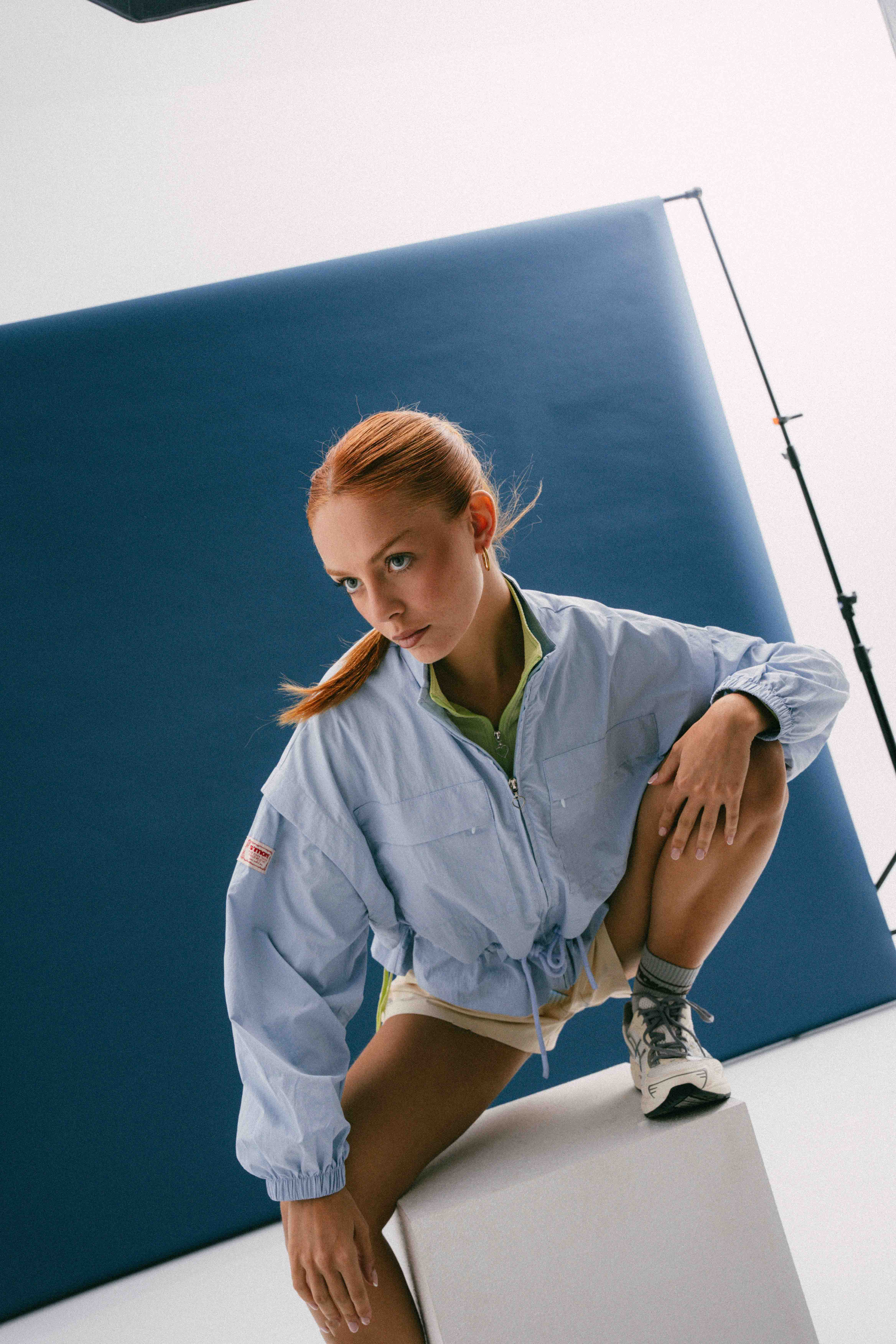 Model in a light blue jacket against a blue studio backdrop in the S’MORE launch campaign