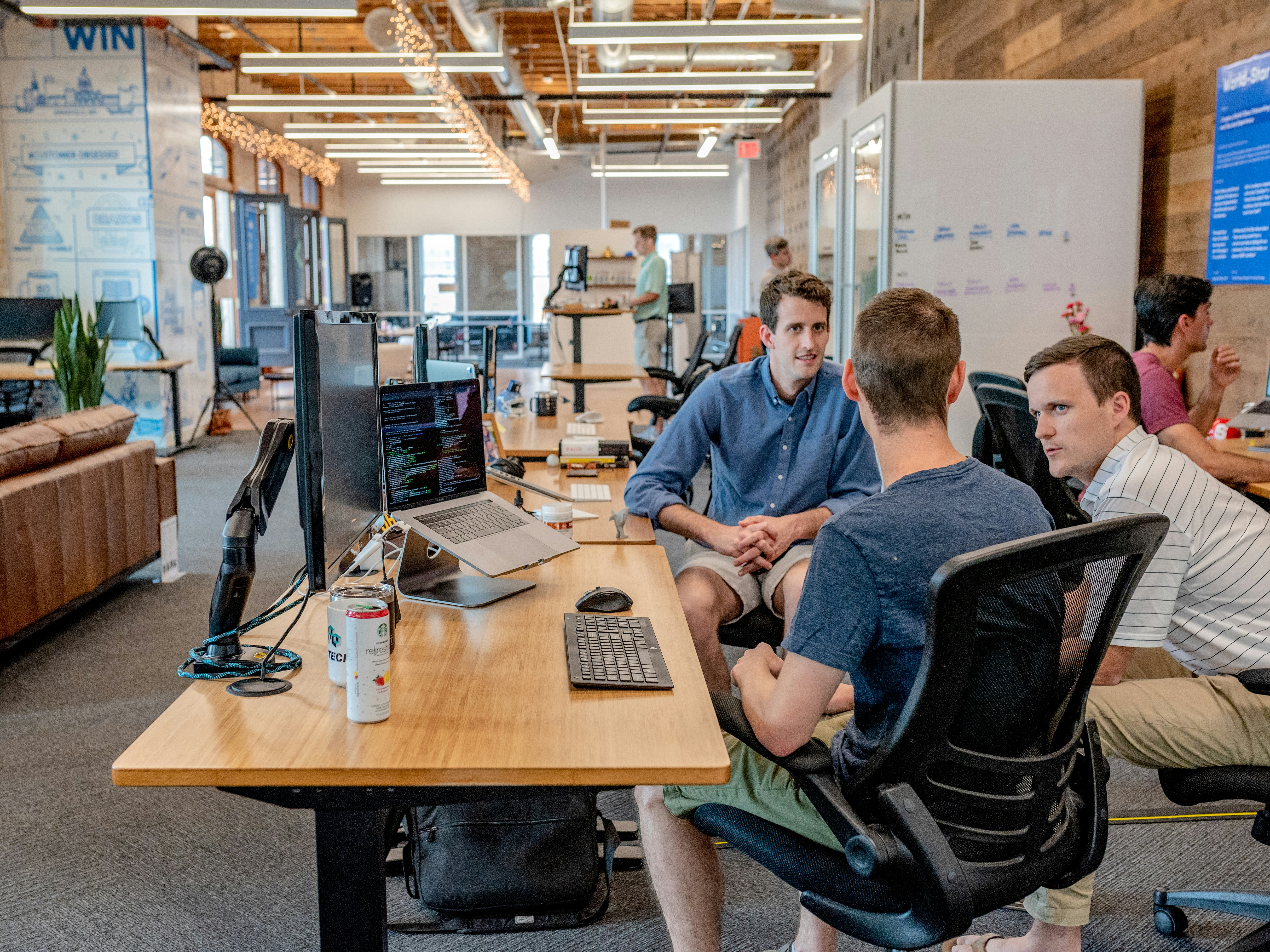 Three men looking at a computer screen in an office.