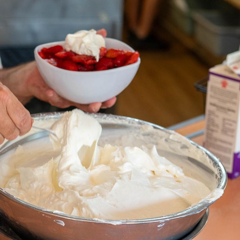 Whipped cream being spooned, wider