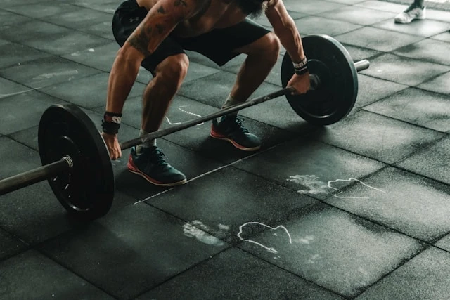 Person lifting a barbell in a gym with a workout energy card overlay