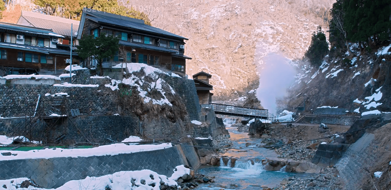 Steam rising from the Yokoyu River valley beside Korakukan ryokan, the heart of an overnight snow monkey trip