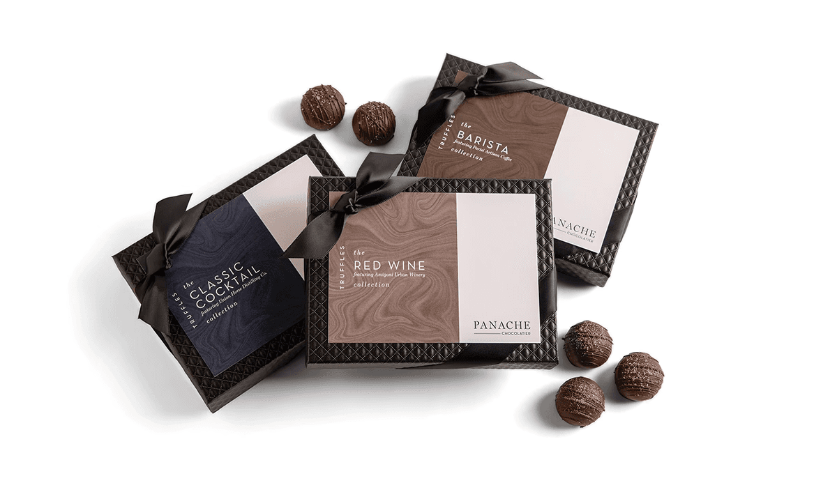 A box of Red Wine truffles, Classic Cocktail truffles and Barista truffles, all featuring a colored marble cover with Panache Chocolatier logo.