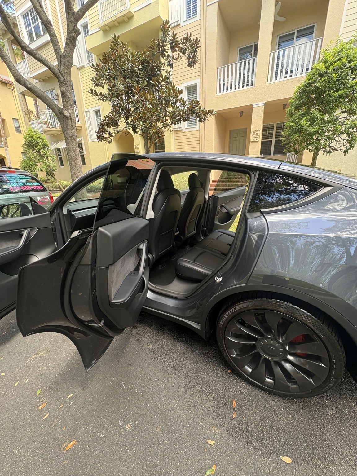 Gray Tesla Model Y with doors open for mobile interior detailing