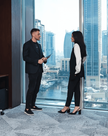 Enclosed meeting room with sound-dampening glass walls, round wooden table, and clean minimalist design.