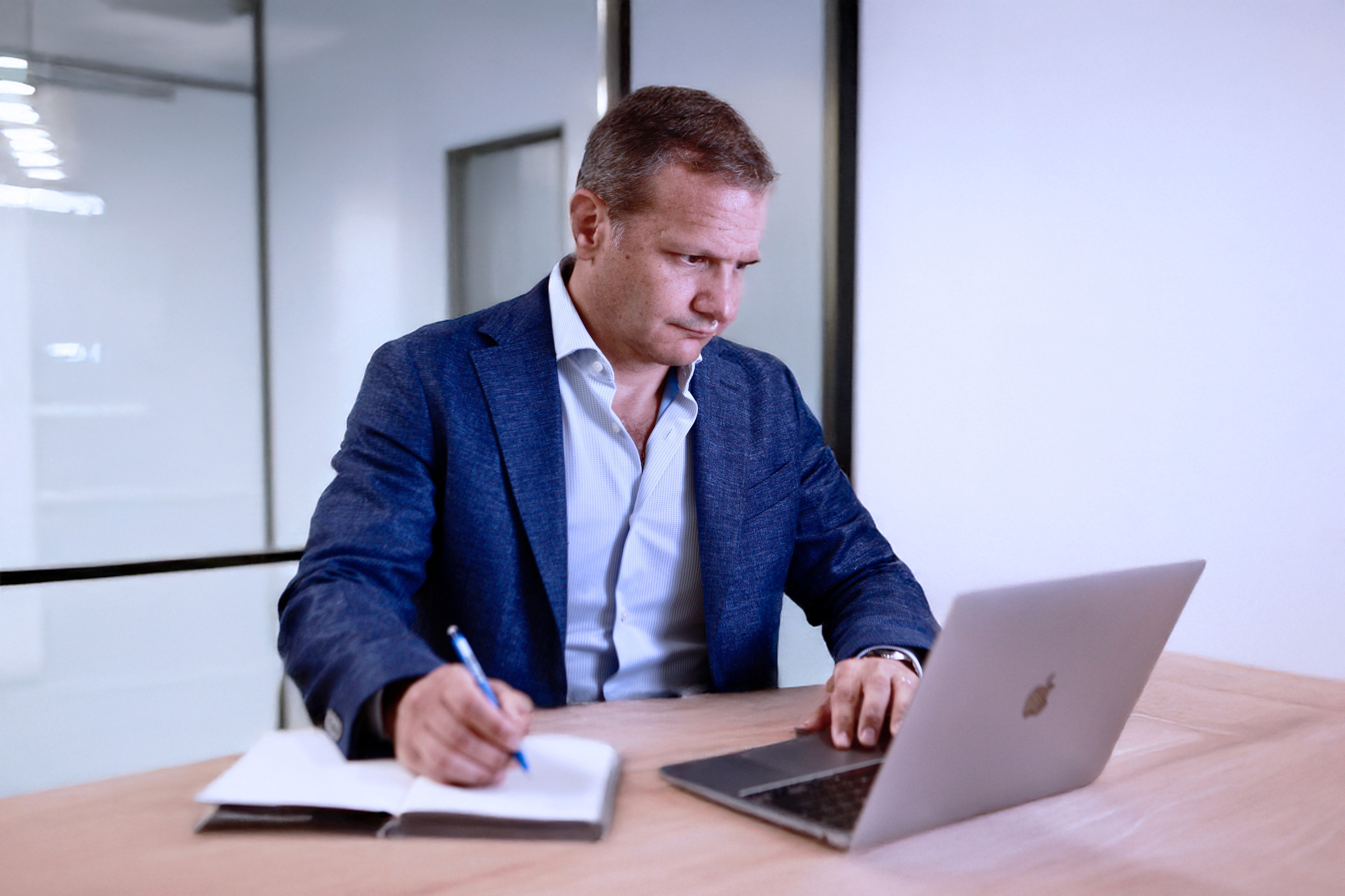 Two people working together on an electronic component, focused on a circuit board with tools visible in the foreground.