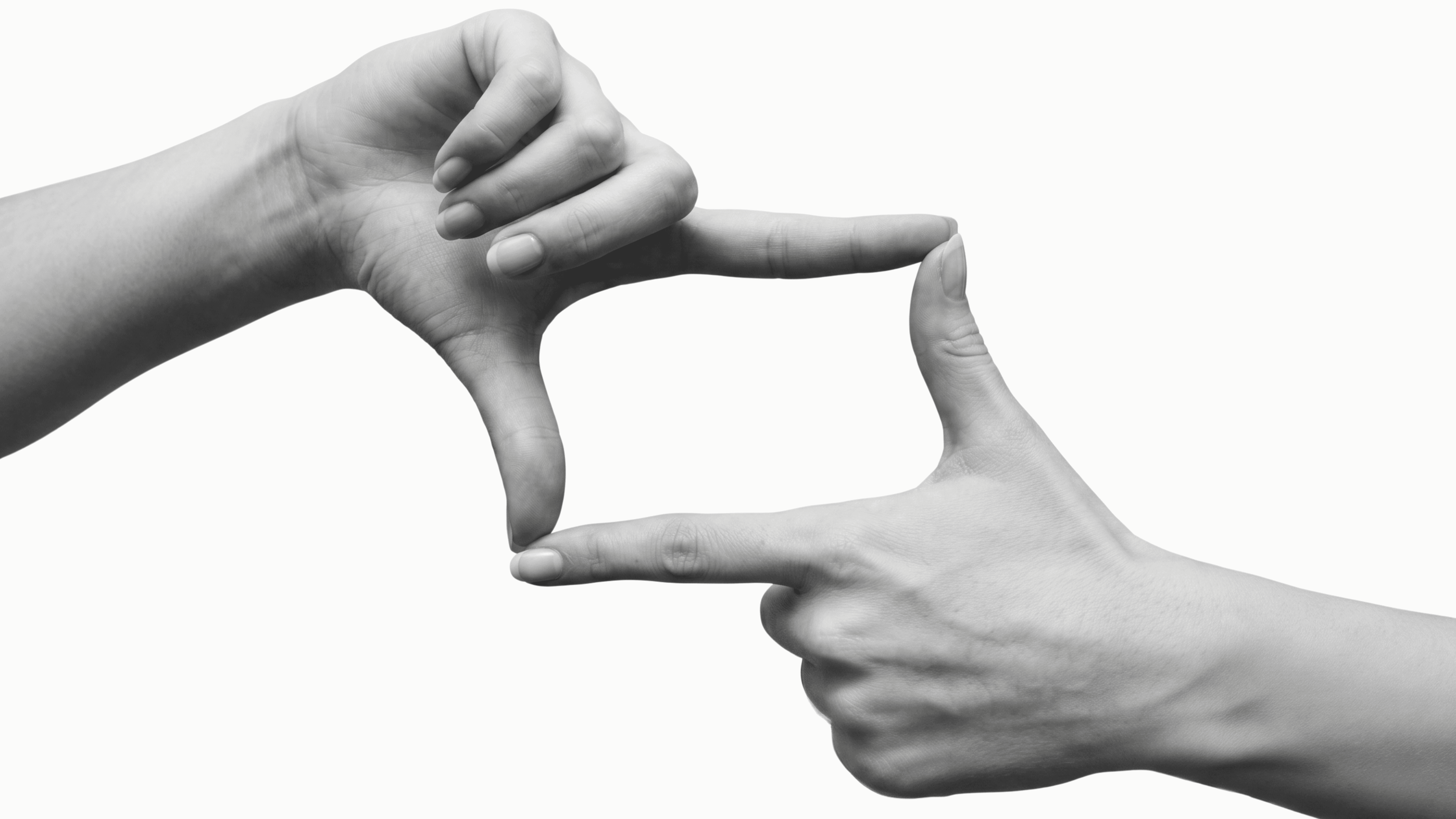 Two hands forming a rectangle frame gesture against a white background, black and white photography, Five Six Studio content capture and creative direction.
