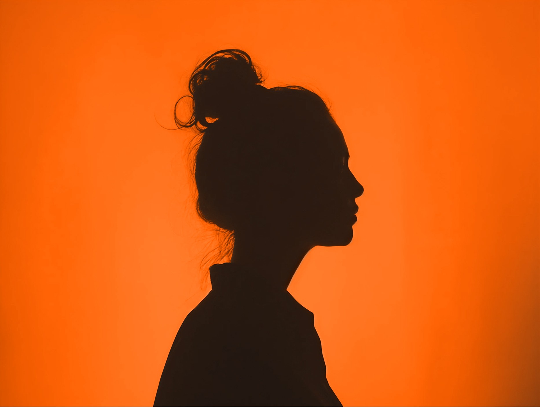 Het silhouette van een vrouw die naar rechts kijkt met een Gilston-Oranje achtergrond.