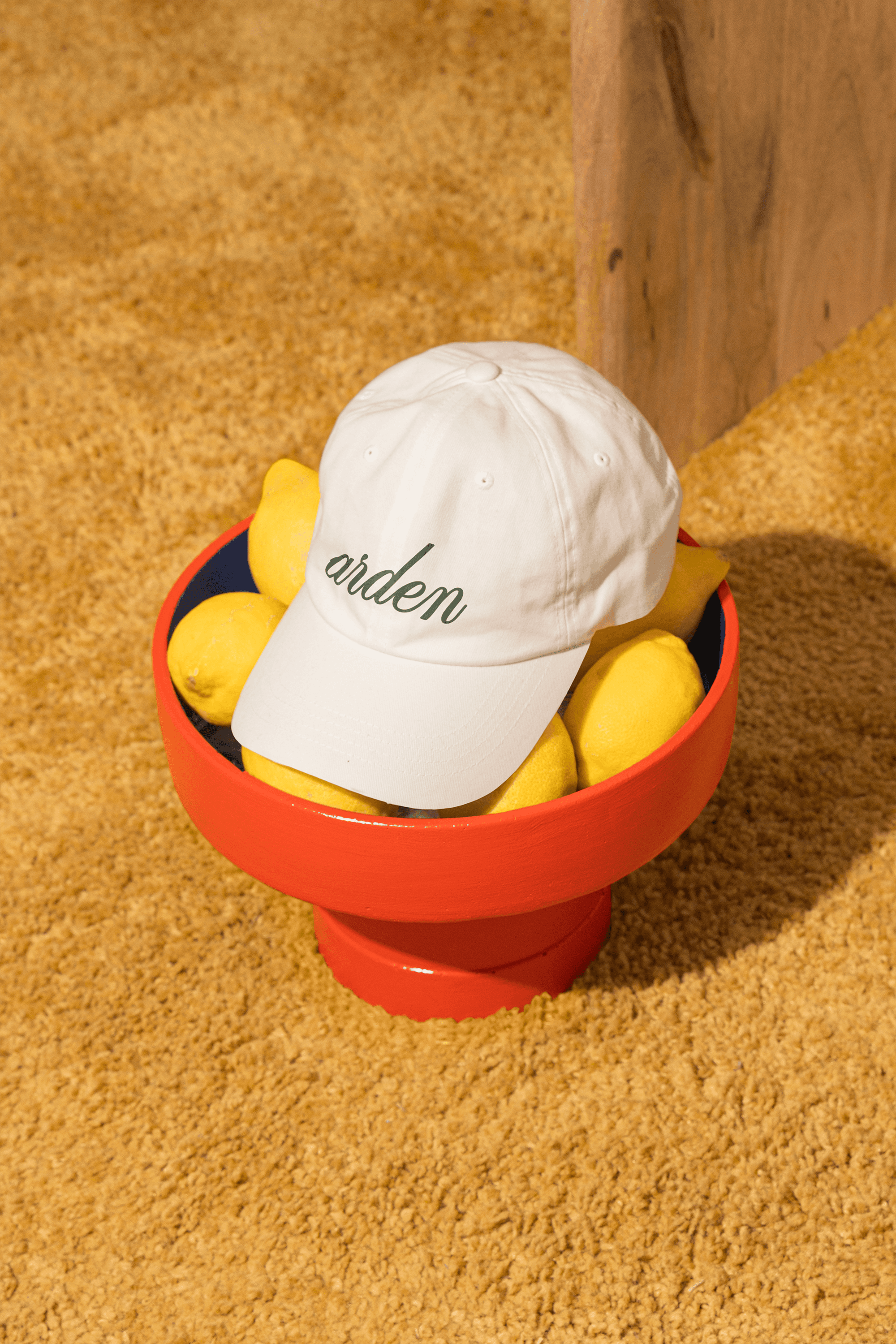 Arden branded white cap styled in a colorful lifestyle setting.