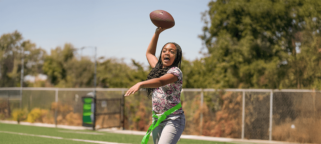 Elementary student throwing a pass during a HOKALI flag football after-school progr