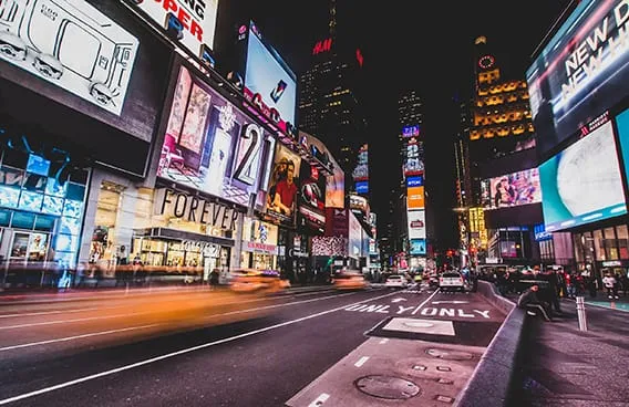 a man walking down a street past a large poster
