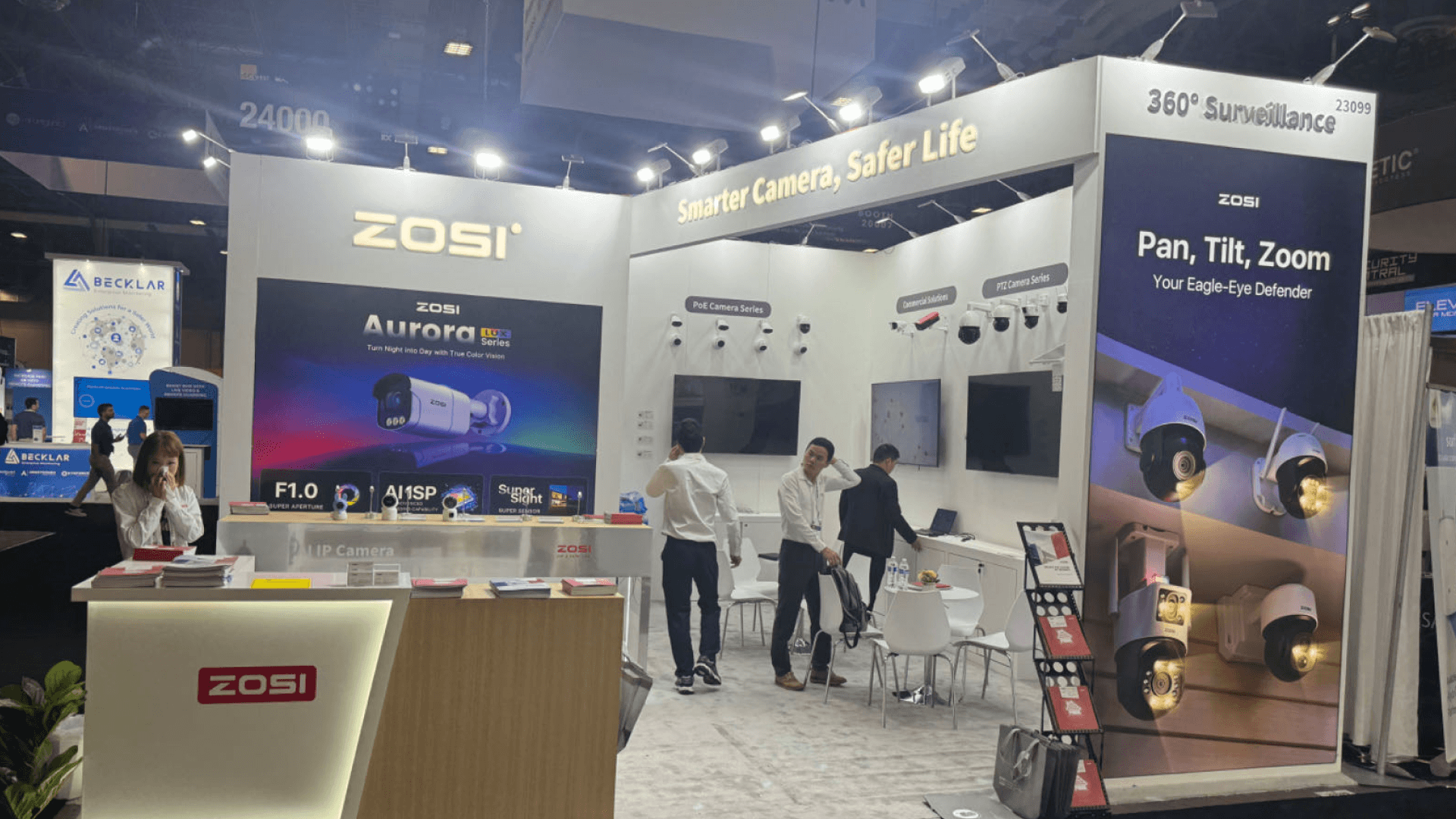 ZOSI ISC West 2024 20x20 surveillance booth at The Venetian Expo with camera category wall, Aurora display graphic, and open meeting layout