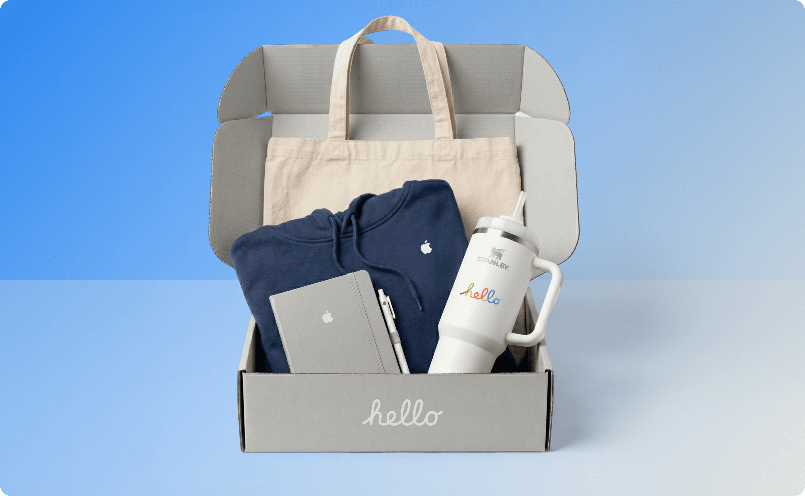 A swag kit containing a tote bag, a blue hoodie, a gray notebook, and a Stanley tumbler.