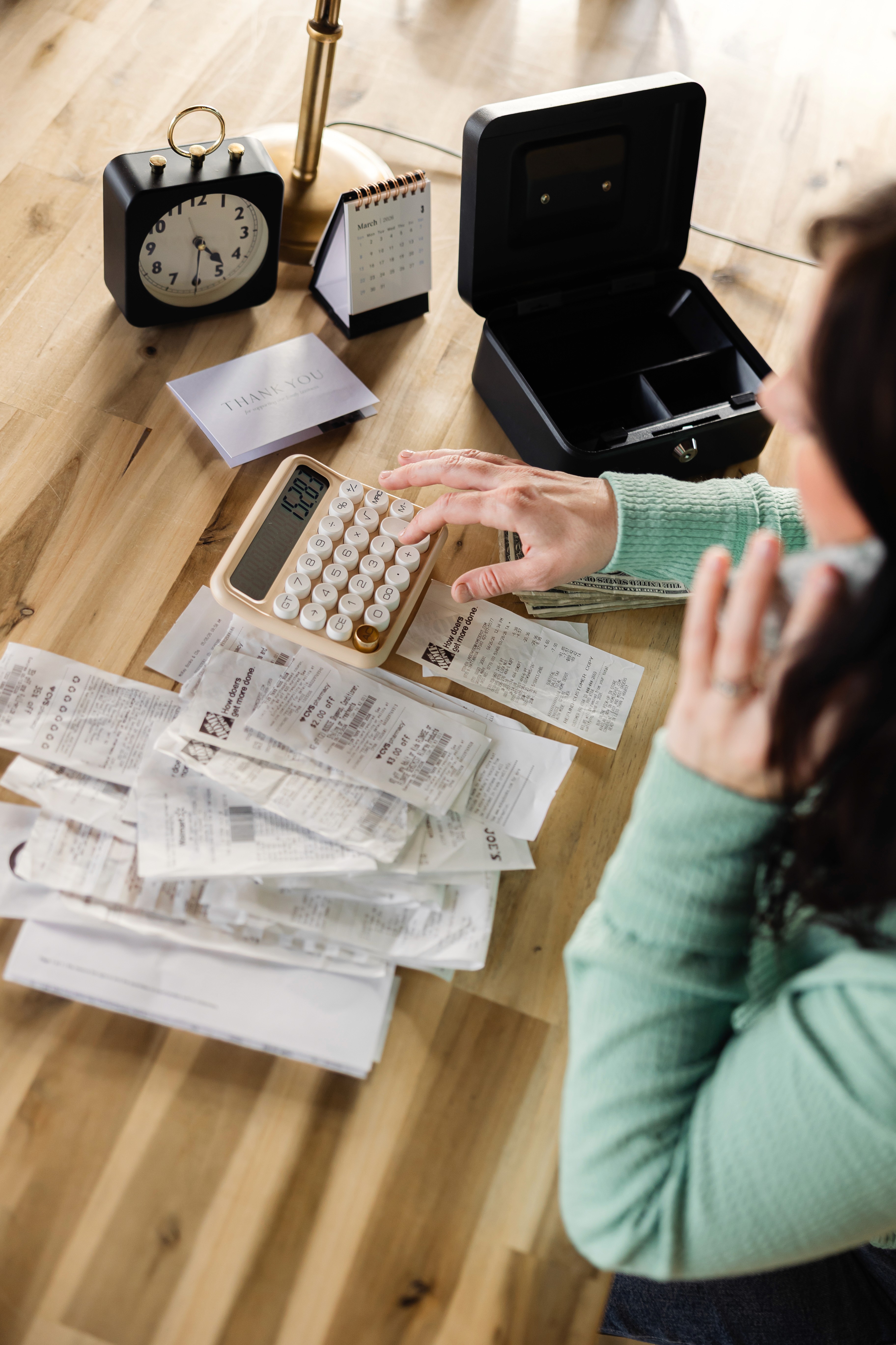 a person sitting at a desk with a calculator and a notebook
