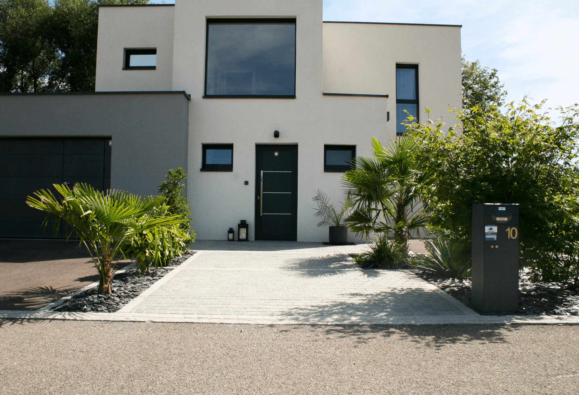 Entrée de maison moderne avec pavage et aménagement végétalisé, réalisée par Acqua Terra dans le Haut-Rhin