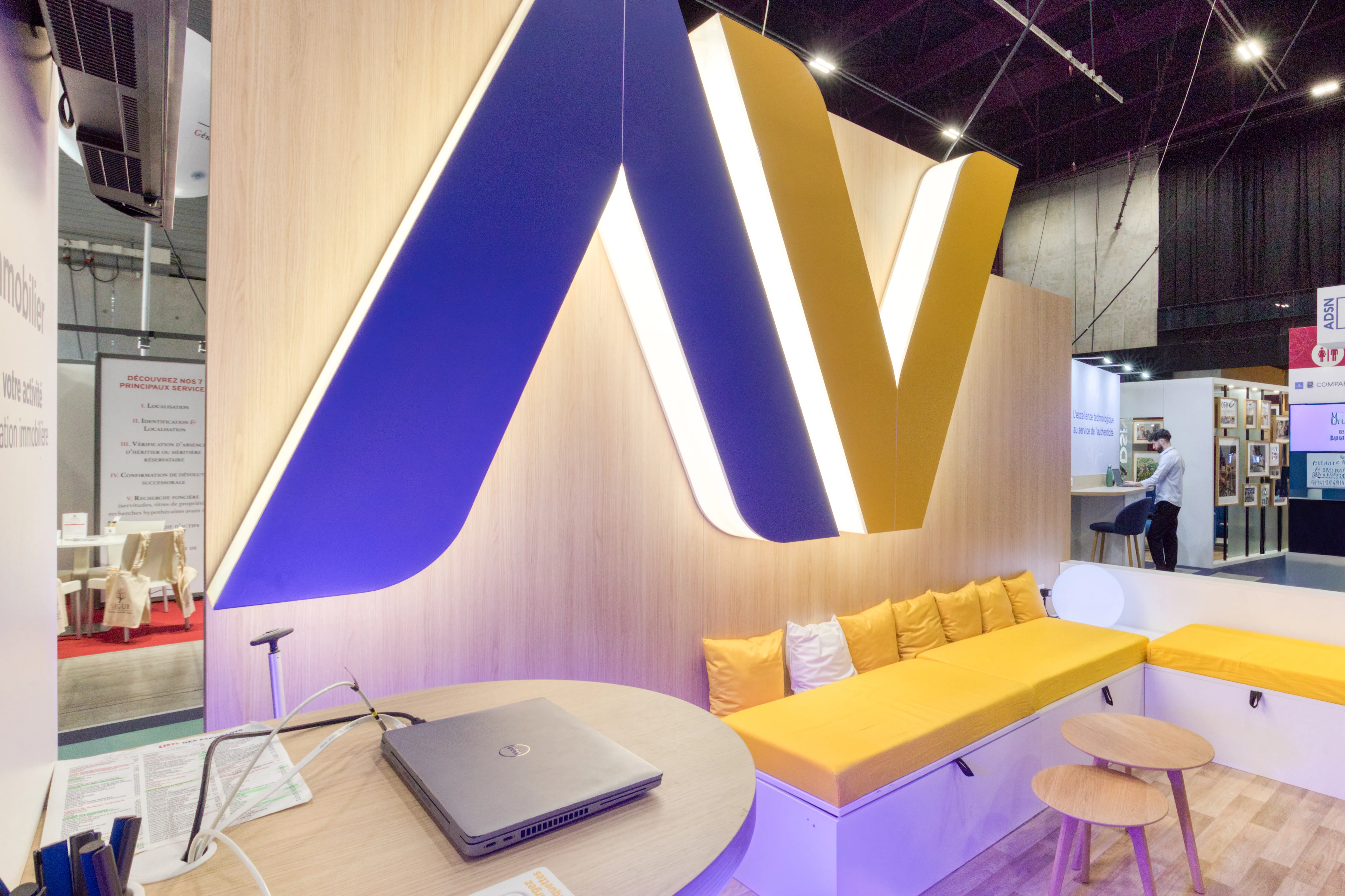  Espace lounge ADNOV avec grand logo lumineux et mobilier sur-mesure au Congrès des Notaires 2025