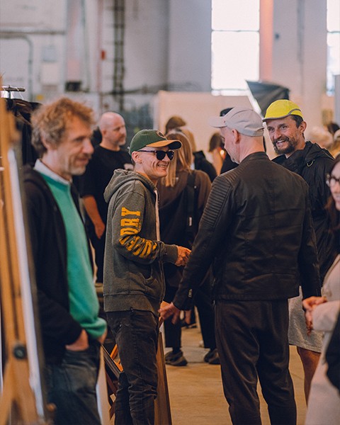 Zdjęcie przedstawiające artystów w rozmowie podczas targów.