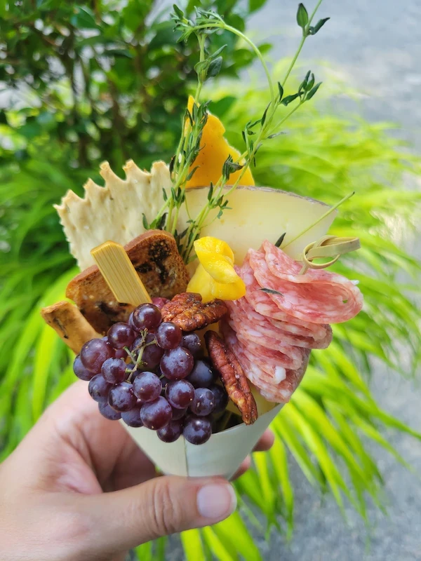 Individual charcuterie cone with grapes, cheese, and salami
