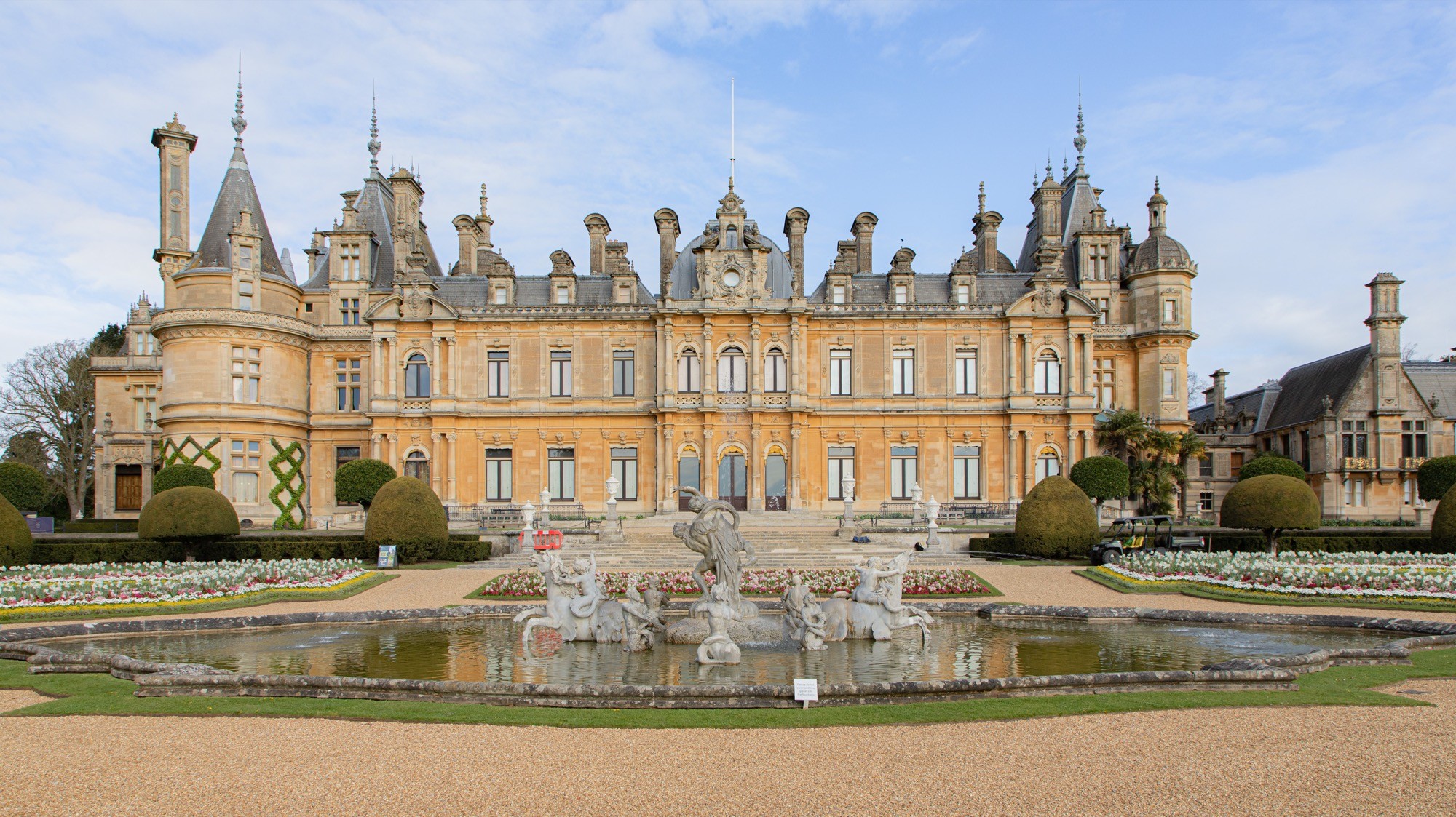 Two classic volkswagen beetles, one green, one cream.
