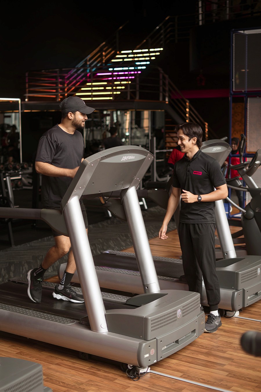 Man Running On ThreadMill With A Personal Training Coach